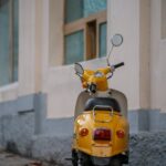 A yellow moped parked against a building wall in Yalta, offering urban charm.