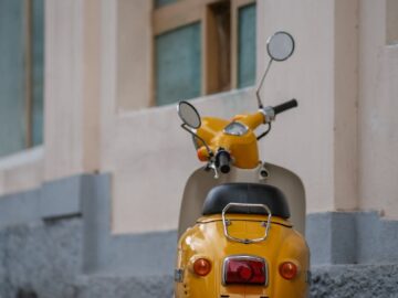 A yellow moped parked against a building wall in Yalta, offering urban charm.