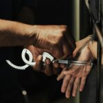 Close-up view of a person being handcuffed in a jail setting, focusing on hands and handcuffs.