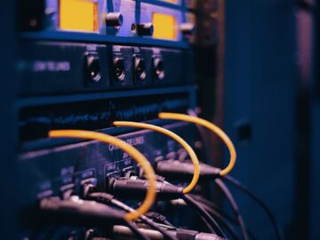 Close-up of network cables and ports in a server rack, showcasing connectivity.
