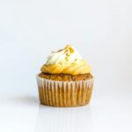 A delectable cupcake with creamy frosting on a white background, perfect for food photography.