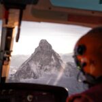 Stunning aerial view of the Matterhorn from a helicopter cockpit, showcasing snow-covered peaks.