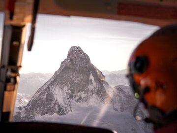 Stunning aerial view of the Matterhorn from a helicopter cockpit, showcasing snow-covered peaks.