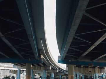 View of a modern urban overpass with vehicles and traffic below, captured in daylight.