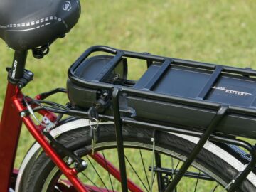 Detailed view of an electric bicycle battery mounted on a rear rack, highlighting the key-lock mechanism.