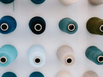 Top-down view of colorful threads neatly arranged on a white background, showcasing vibrant shades.