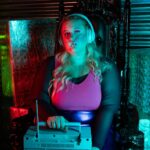 Woman with headphones and radio sitting amidst stacks of dollar bills.