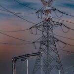 Towering power lines stand against a dramatic sky in Srinagar, showcasing electricity's reach.