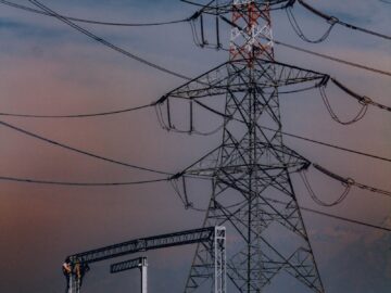 Towering power lines stand against a dramatic sky in Srinagar, showcasing electricity's reach.