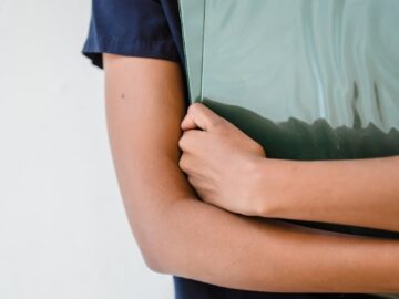 A professional holding a green binder, symbolizing organization and efficiency.