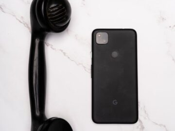 Comparison of a vintage handset with a modern smartphone on a marble surface.
