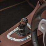 Close-up of a luxury car interior focusing on gear stick and dashboard details.