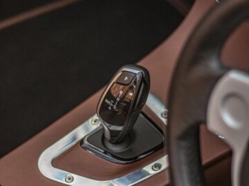 Close-up of a luxury car interior focusing on gear stick and dashboard details.