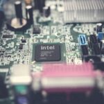 Detailed image of a computer motherboard highlighting an Intel chip with surrounding components.