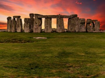 Capture of the iconic Stonehenge during a vibrant sunset with a dramatic sky.