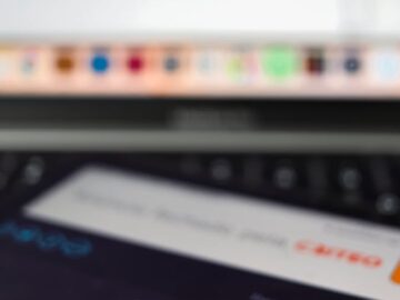 Close-up of a smartphone showing internet speed test results with a laptop in the background.