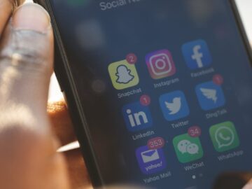 Close-up of a smartphone showing various social media applications being used.