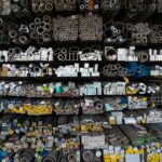 Diverse collection of stacked metallic pipes and rods in a warehouse display.