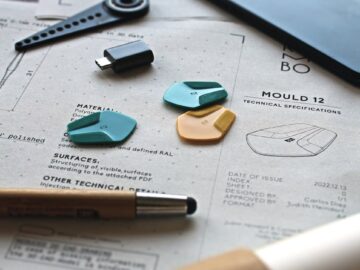 Close-up of a creative workspace featuring schematics, guitar picks, and design tools.