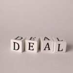 Close-up of white cubes with black letters forming the word 'Deal', ideal for business negotiations or agreements theme.
