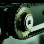 Detailed view of a rusty chain mechanism with a metal wheel, showcasing industrial engineering.