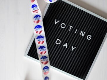 Close-up of a Voting Day sign and roll of I Voted stickers.