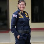 Asian female police officer smiling confidently while standing outdoors in Jakarta.