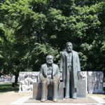 Statues of Karl Marx and Friedrich Engels in Berlin park, sunny day.