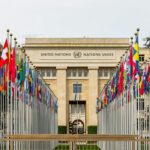 View of the United Nations Office in Geneva adorned with flags of various countries.