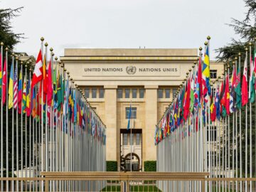View of the United Nations Office in Geneva adorned with flags of various countries.