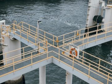 Aerial view of industrial pier with railings above water in Delta, BC, Canada.
