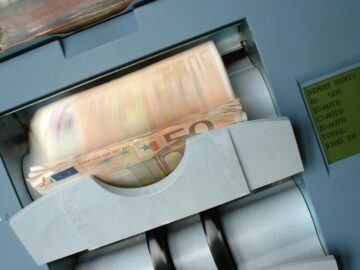 50 Euro banknotes being processed in a high-speed counting machine, showcasing technology and finance in action.