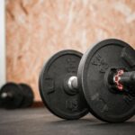 Rustic gym scene showing close-up of dumbbells for weight training.