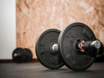 Rustic gym scene showing close-up of dumbbells for weight training.