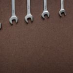 Top view of wrenches lined up on a textured brown surface, showcasing sizes.