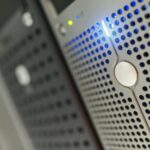 Focused detail of a modern server rack with blue LED indicators in a data center.