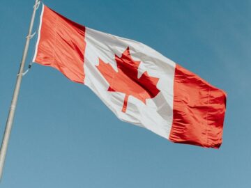 A Canadian flag waving gracefully against a clear blue sky in Dartmouth, NS.