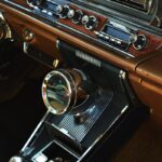 Interior view of a vintage car dashboard featuring retro audio equipment and classic design elements.