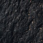 Detailed texture of a rugged volcanic rock formation showcasing unique natural patterns.