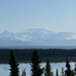a lake surrounded by trees and a mountain in the background
