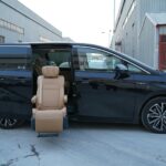 Black minivan parked outdoors with open door displaying an accessible seat feature on a cold winter day.