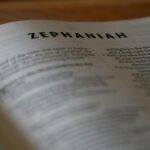 Close-up of an open Bible page highlighting the book of Zephaniah with selective focus.