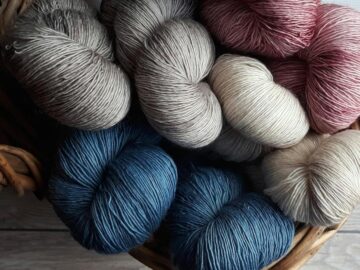 A collection of colorful yarn skeins in a basket, perfect for knitting and crafting projects.