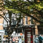 A vibrant street scene in Chester, England featuring a classic red telephone booth.