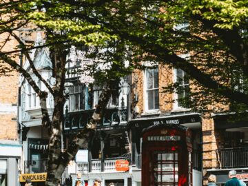 A vibrant street scene in Chester, England featuring a classic red telephone booth.