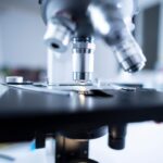 Detailed view of a laboratory microscope focusing on lens and optical components.