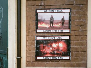 Interior of a rustic urban wall featuring thought-provoking fire posters.