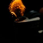 A detailed close-up of sparks igniting from a lighter, capturing the heat and fire ignition moment.