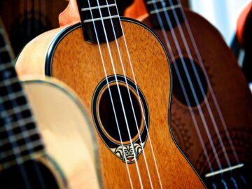 Detailed view of classic acoustic guitars and ukuleles showcasing wooden textures and design.