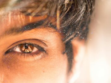 A detailed close-up of a human eye with dust particles reflecting natural light.